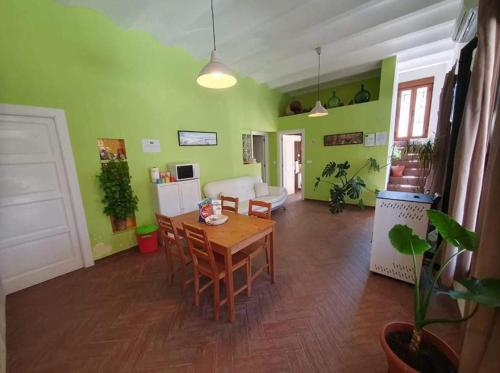 een woonkamer met een houten tafel en groene muren bij Vivienda Rural Embalse San Clemente in Huéscar