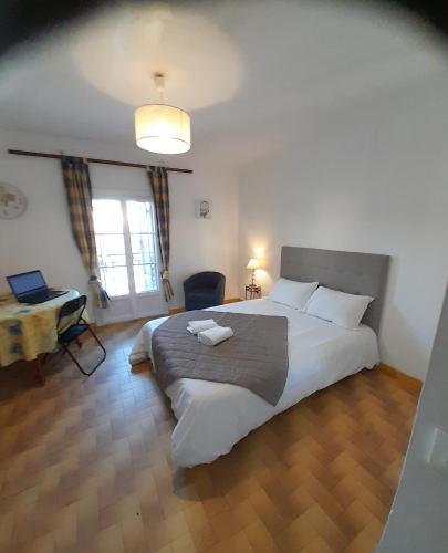 une chambre avec un grand lit blanc et un bureau dans l'établissement Stella Apartment - Cannes, à Cannes