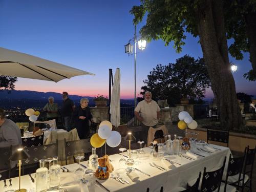 grupa ludzi stojących przy stole ze światłami w obiekcie AGRITURISMO Villino Bellavista w mieście Spoleto