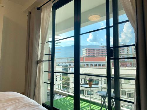 a bedroom with a window with a view of a building at Chomdoi Apartment,Mountain View,near nimman,pool,Wifi in Chiang Mai