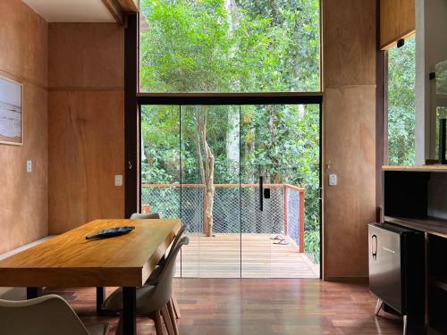 a dining room with a table and a large window at Bonito Paraiso Ilha Grande in Abraão