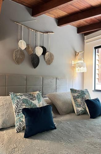 a room with a bed with pillows and baskets on the wall at Bonito Paraiso Ilha Grande in Abraão