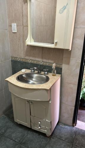 uma casa de banho com um lavatório e um espelho em Leon Ezeiza Apartment em Monte Grande