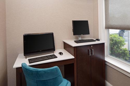 a desk with a laptop and a monitor and a chair at Residence Inn Boston Dedham in Dedham