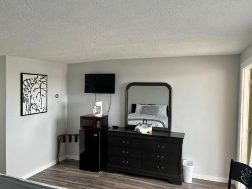 a bedroom with a dresser and a mirror at Lincoln House Motel in Lincoln