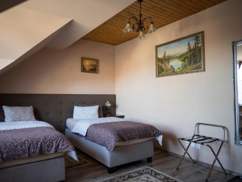 a bedroom with two beds and a painting on the wall at Penzión ROYAL in Bytča