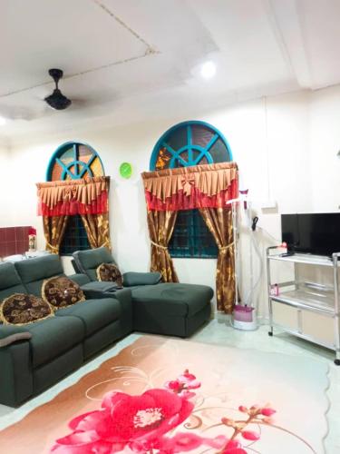 a living room with a couch and two windows at Roomstay Kuala Terengganu in Kuala Terengganu