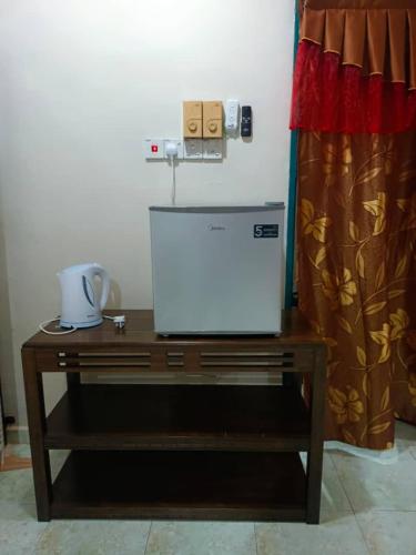 a wooden table with a white appliance on top of it at Roomstay Kuala Terengganu in Kuala Terengganu