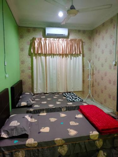 a bedroom with two beds and a window at Roomstay Kuala Terengganu in Kuala Terengganu