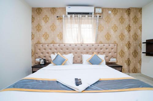 1 dormitorio con 1 cama blanca grande con almohadas azules en Hotel Accor Inn, en Bangalore