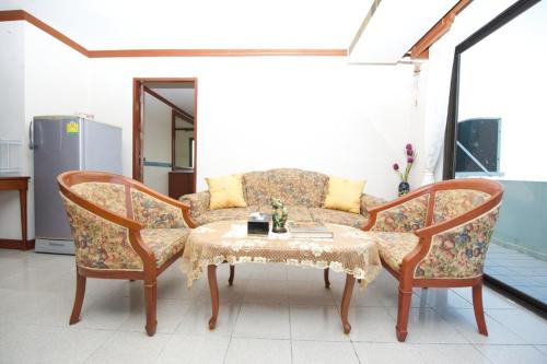 a living room with a couch and a table at Poonchock Mansion in Bangkok