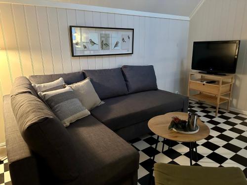 a living room with a couch and a table at Tollgaarden Gjestegaard in Larvik