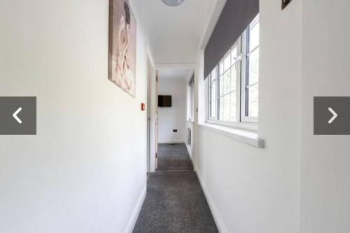 einen Flur mit weißen Wänden und einem Fenster in der Unterkunft 1 Bed Balcony View Bedworth in Bedworth