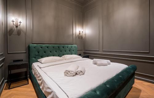 a bedroom with a large bed with towels on it at Emerald deluxe apartment - City Center in Tbilisi City