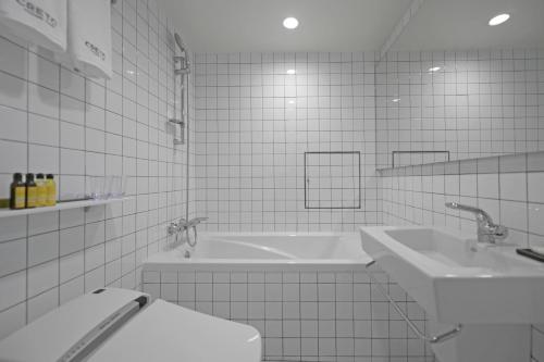 a bathroom with two sinks and a toilet and a tub at Creto Hotel Myeongdong in Seoul