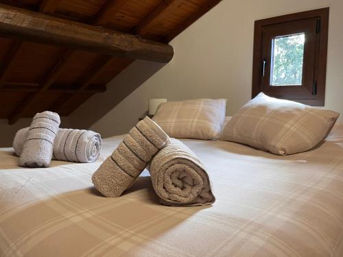 Una cama con toallas enrolladas encima. en Ca Luena 