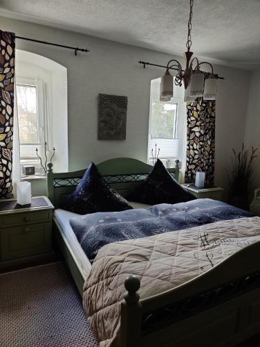 a bedroom with a bed with blue sheets and pillows at Landwohnung Max&Fritz in Schauenstein