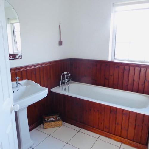 a bathroom with a bath tub and a sink at Springfields 