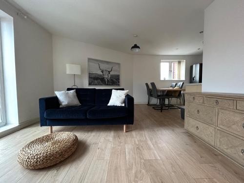 a living room with a blue couch and a table at Stafford 2 Bedroom Apartment in Prime Location with Secure Parking in Stafford