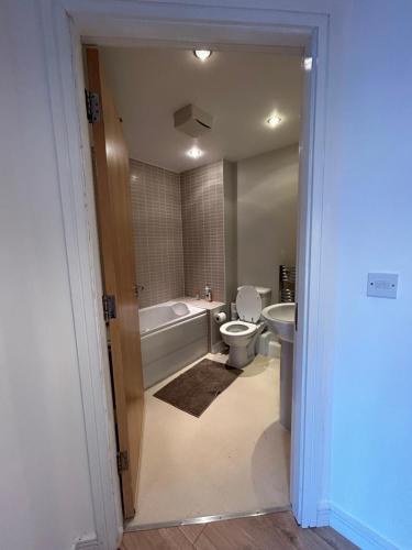 een badkamer met een bad, een toilet en een wastafel bij Stafford 2 Bedroom Apartment in Prime Location with Secure Parking in Stafford