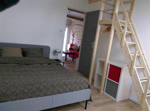 une chambre avec un lit et une échelle en bois dans l'établissement Gîte de charme à proximité de Fontainebleau et Moret sur Loing, à Valence-en-Brie
