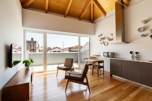 a kitchen and dining room with a large window at Pensao O Laranjeira in Viana do Castelo