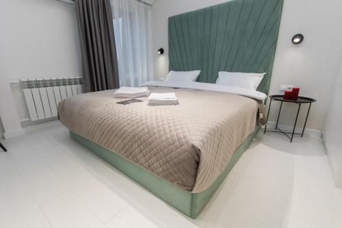 a bedroom with a large bed with a green headboard at LUX Апартаменти MYFREEDOM поруч метро Театральна, Хрещатик in Kyiv