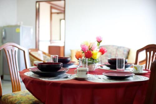 曼谷的住宿－蓬喬克公館酒店，桌子上放有盘子和杯子,花朵