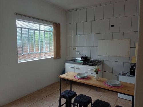 a kitchen with a table and some stools in it at Apto confortável com Churrasqueira 02 in Cachoeira do Sul