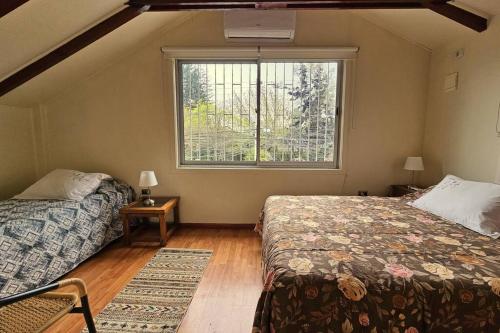 1 dormitorio con 2 camas y ventana en Casa muy bien ubicada cercana al metro y a mall, en Santiago