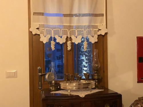 una ventana con una cortina sobre una mesa en Hotel Kaso Ervehe en Përmet