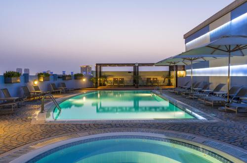 a swimming pool on the rooftop of a hotel at Coral Dubai Deira Hotel in Dubai