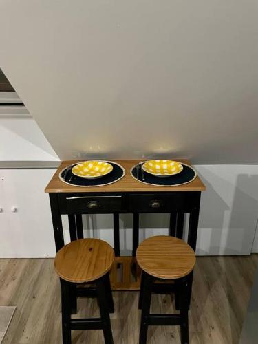 une petite table avec deux assiettes et deux tabourets dans l'établissement L’essentiel, à Amiens