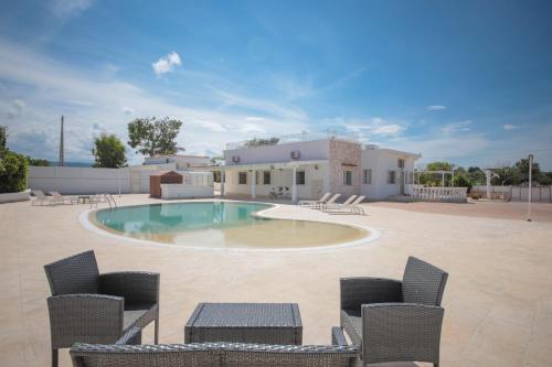 a swimming pool with chairs and a house at Villa Ginevra la Dimora by Apulia Hospitality in Capitolo
