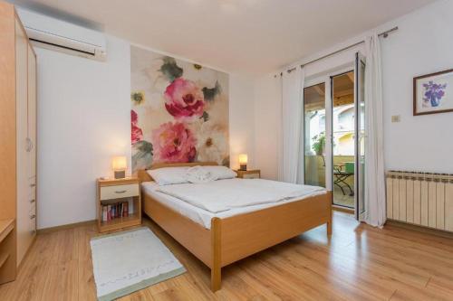 a bedroom with a bed and a painting on the wall at Guesthouse Casa Nova in Poreč