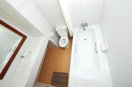 a bathroom with a tub and a toilet in it at Poonchock Mansion in Bangkok