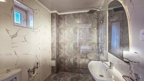 a bathroom with a shower and a sink and a tub at Hotel Bankir Khiva in Khiva