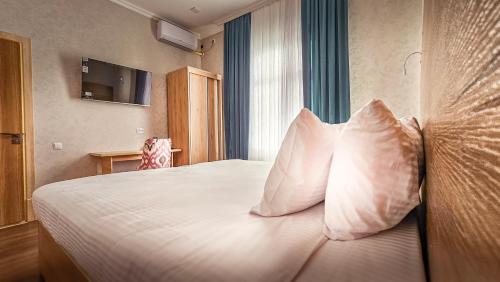 a bedroom with a bed with white sheets and pillows at Hotel Bankir Khiva in Khiva