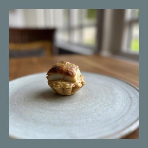 a pastry sitting on a plate on a table at Rafters at Riverside House Hotel in Bakewell