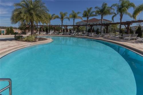 a large swimming pool at a resort with palm trees at New Home Close To Disney Bliss! in Kissimmee