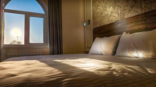 a bedroom with a large bed with a window at Hotel Bankir Khiva in Khiva