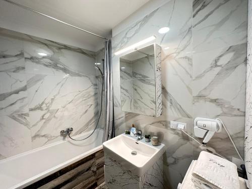 een witte badkamer met een wastafel en een douche bij Deluxe Cozy Apartments - Coresi Mall #Brasov in Braşov