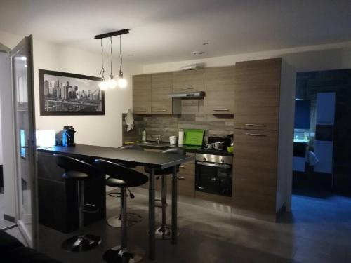 a kitchen with a table and two bar stools at Appartement spacieux &très calme. Spacious & very quiet apartment. in Carros