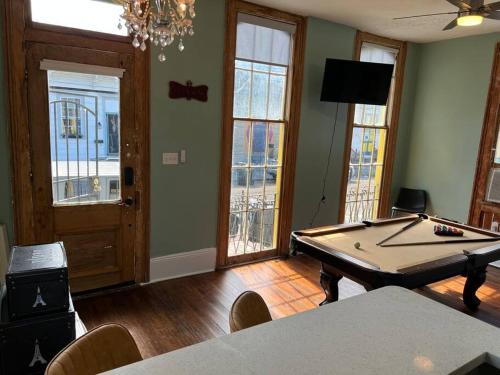 a living room with a pool table and windows at Chilled Pad 2 Blocks from the French Quarters in New Orleans