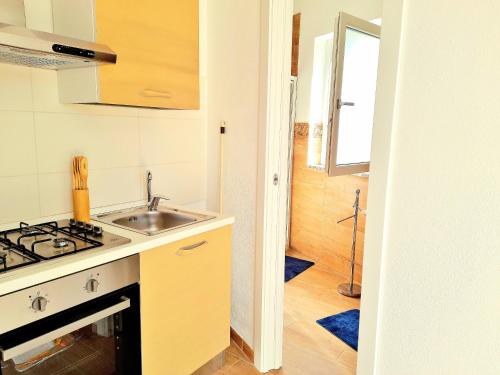 a kitchen with a sink and a stove at casa vacanze gioema baunei in Baunei