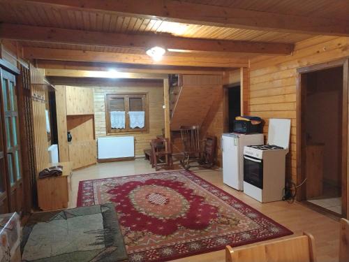 ein Wohnzimmer mit einem Teppich auf dem Boden in der Unterkunft Cabana DUY-KAY in Lacul Roşu