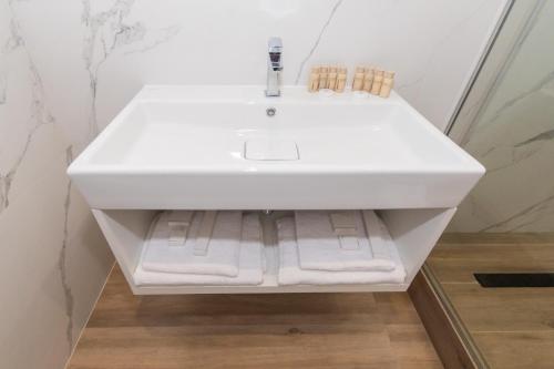a white sink in a bathroom with white towels at LUX Апартаменти MYFREEDOM поруч метро Театральна, Хрещатик in Kyiv