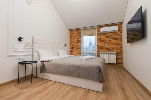 a bedroom with a large bed and a television at LUX Апартаменти MYFREEDOM поруч метро Театральна, Хрещатик in Kyiv