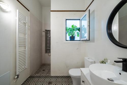 łazienka z umywalką, toaletą i oknem w obiekcie Central5 Boutique Apartments with Common Garden Next to Metro w Atenach