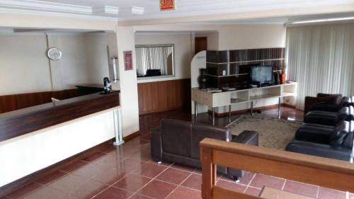 ein Wohnzimmer mit einem Sofa und einem TV in der Unterkunft Hotel Boa Vista in Chapecó